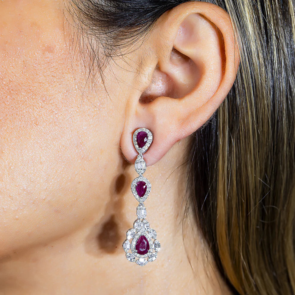 A woman wearing a 14K White Gold Ruby & Diamond Three Tier Drop Earrings